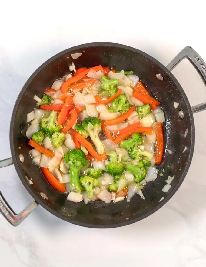 Vegetables are fried in a pan.
