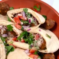 A large plate with Falafel Pita Sandwich.