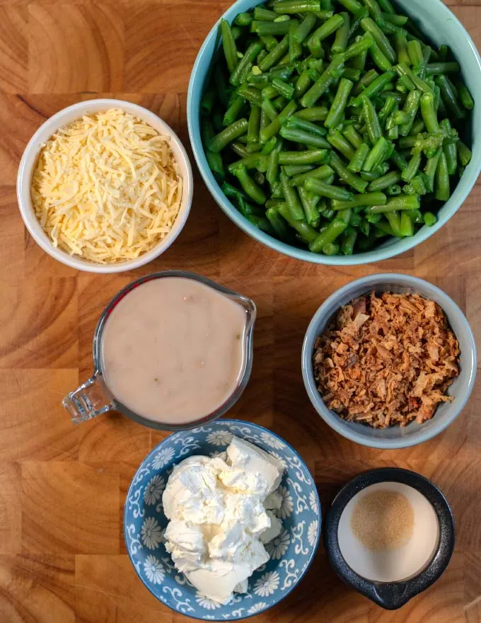 Ingredients needed for making Green Bean Casserole with Cream Cheese on a board.