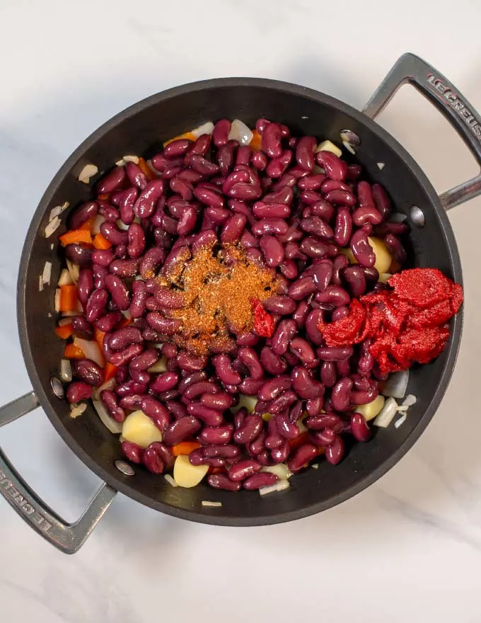 Step-by-step guide showing the addition of red beans and spices to the pan.