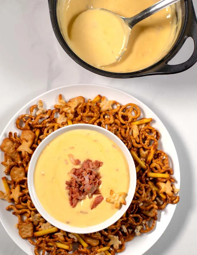 Serving of Beer Cheese Dip with prtzels and the cooking pan in the background.