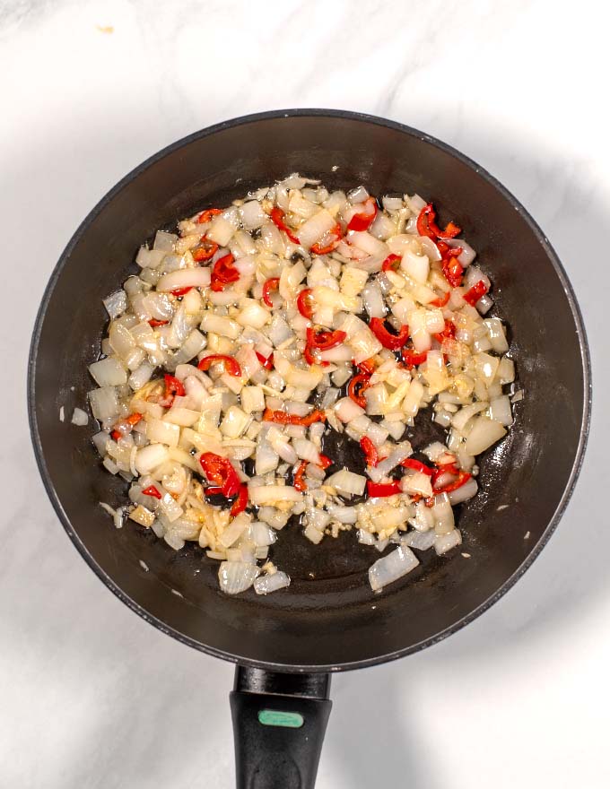 View of a pan in which onions and red chili are fried.