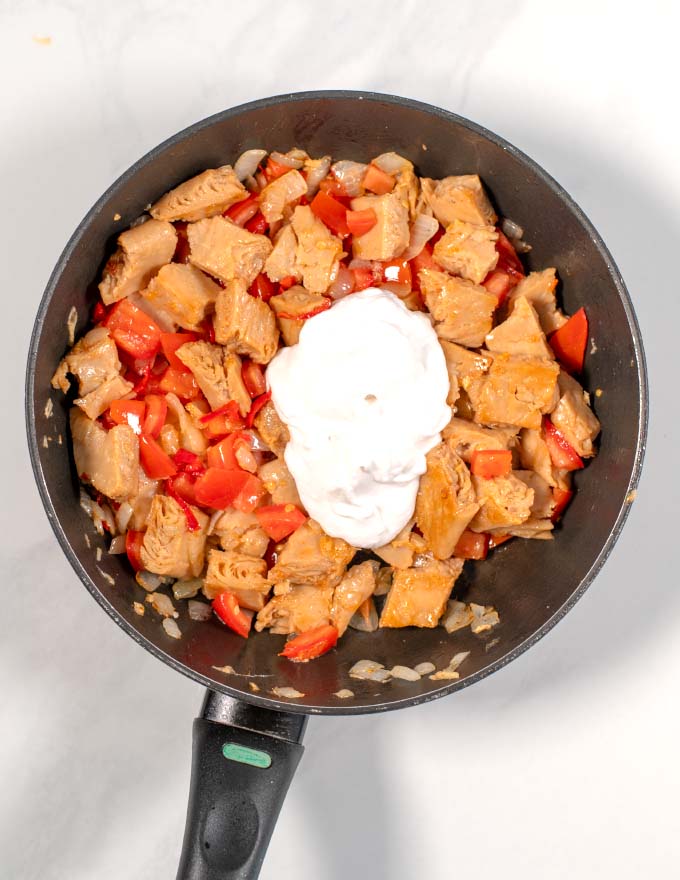 A large dollop of vegan yogurt is added to the pan.