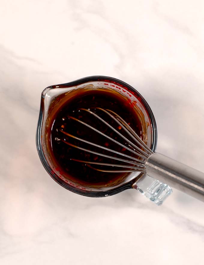 A wire whisk in a mixing bowl.