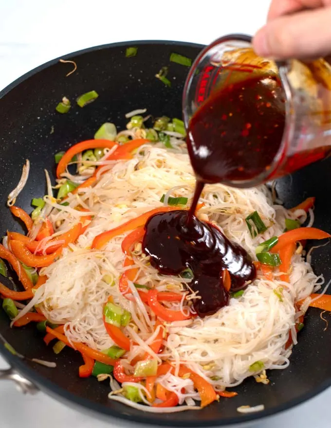 Pouring Pad Thai Sauce with Ketchup over stir fry.