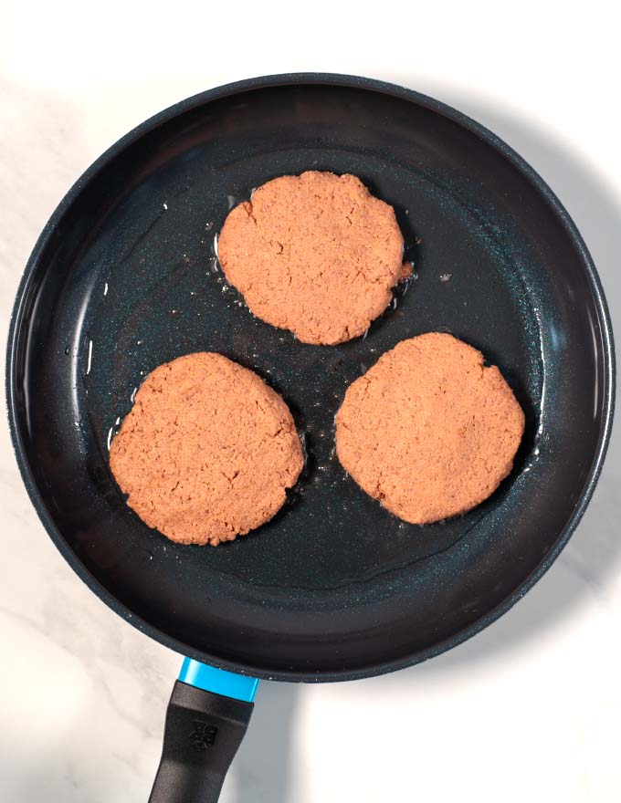 View of a frying pan with three Southern Sausage patties.