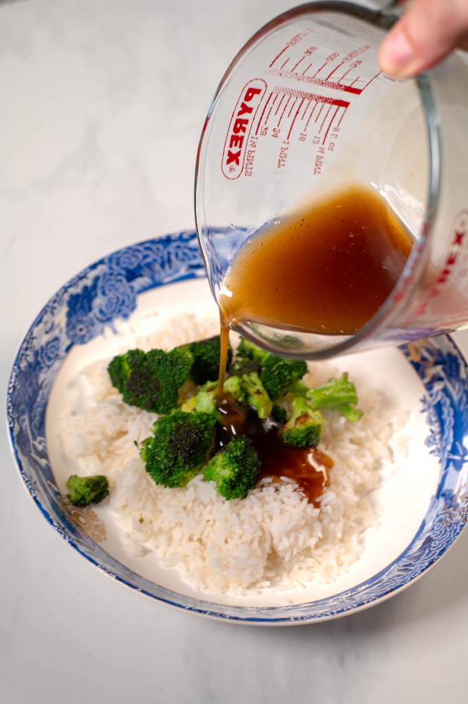 Thai Brown Sauce is poured over a serving of white rice with broccoli.