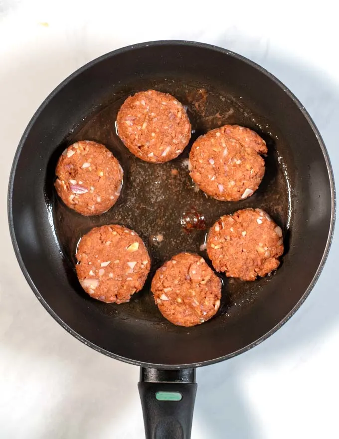 Six meatballs in a frying pan.