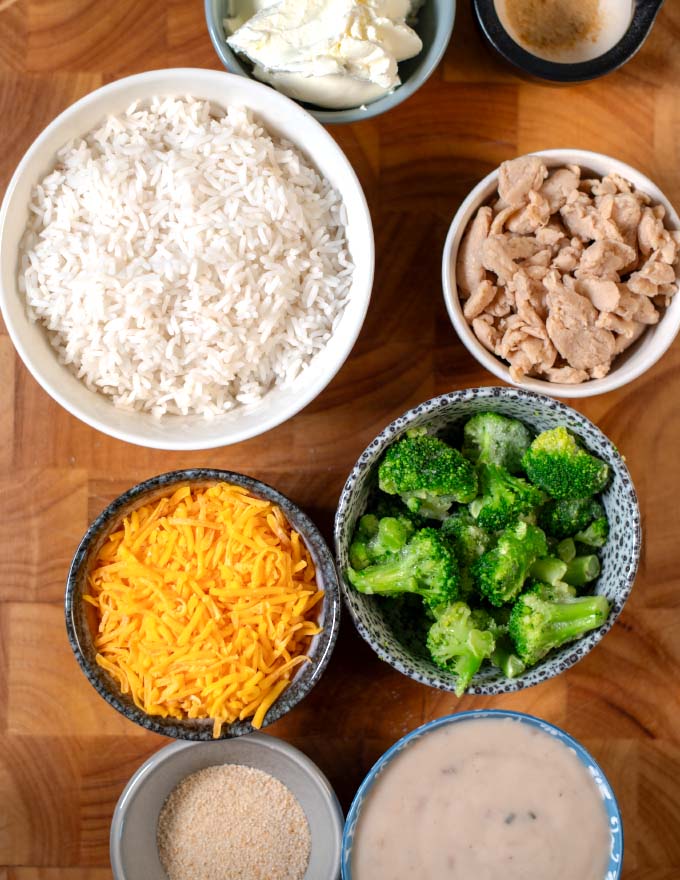 Ingredients needed to make Chicken Divan Curry Casserole on a wooden board.