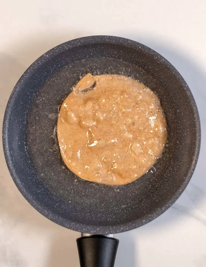 Tortillas are fried in a small pan.