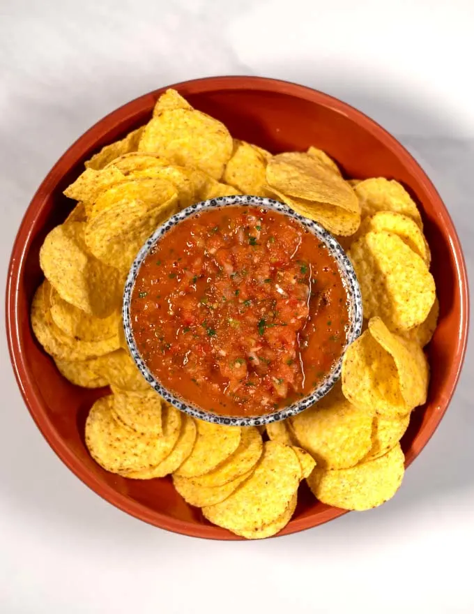 Top view of a serving of Salsa Roja with chips.