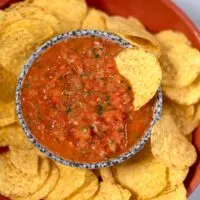 A chip is dipped in Salsa Roja.