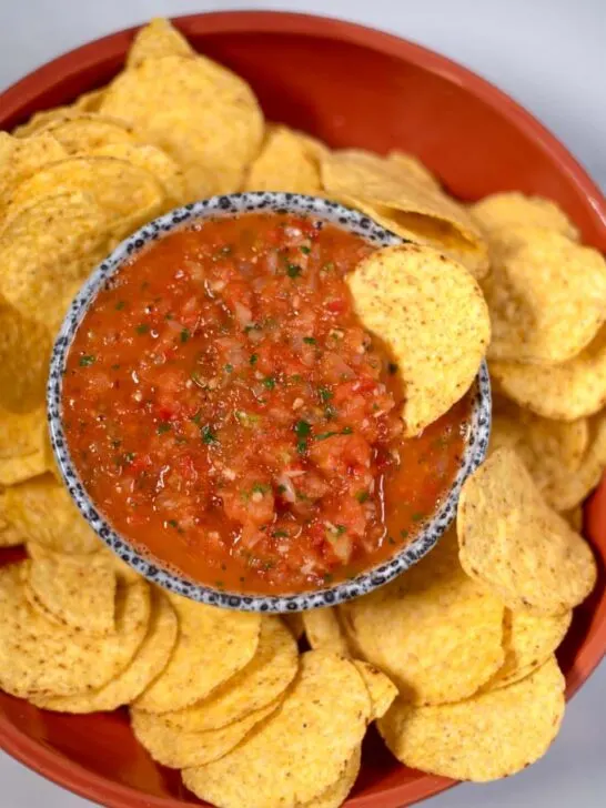 A chip is dipped in Salsa Roja.