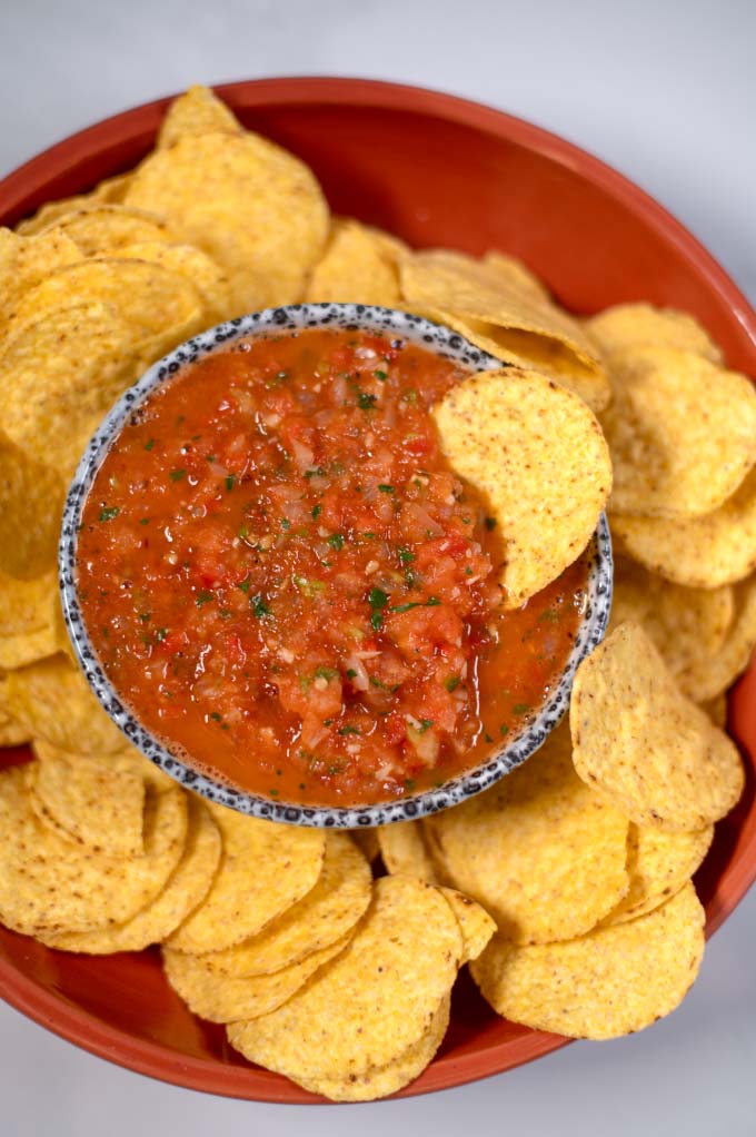 A chip is dipped in Salsa Roja.