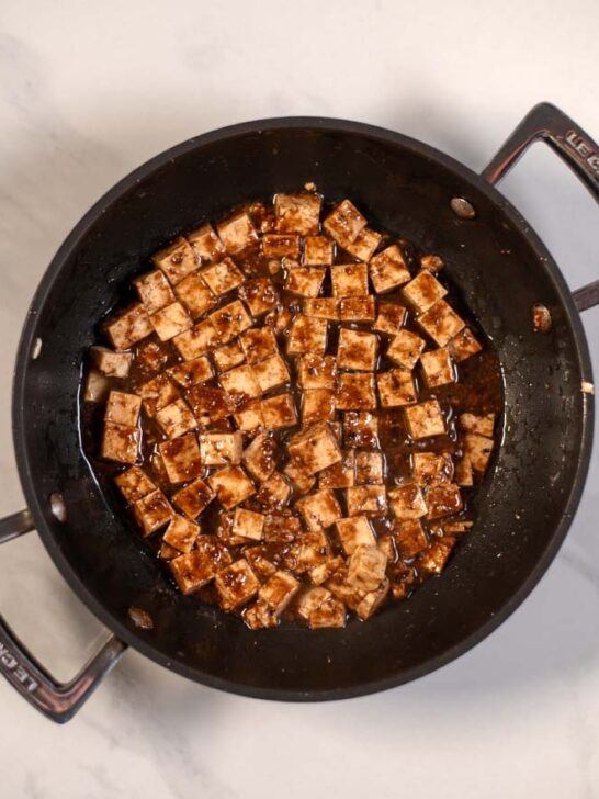 A frying pan with tofu cubes.