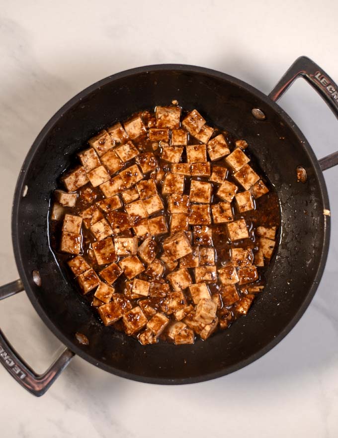 A frying pan with tofu cubes.