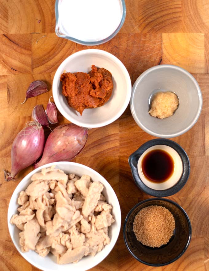 Ingredients needed to make Thai Red Curry on a wooden board.