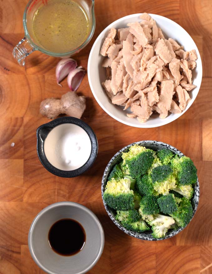 A board with the ingredients needed to make Chinese Chicken and Broccoli.