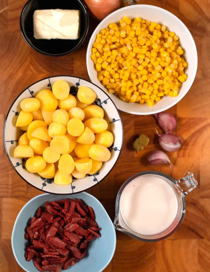 Ingredients needed to make easy Corn Chowder collected on a board.