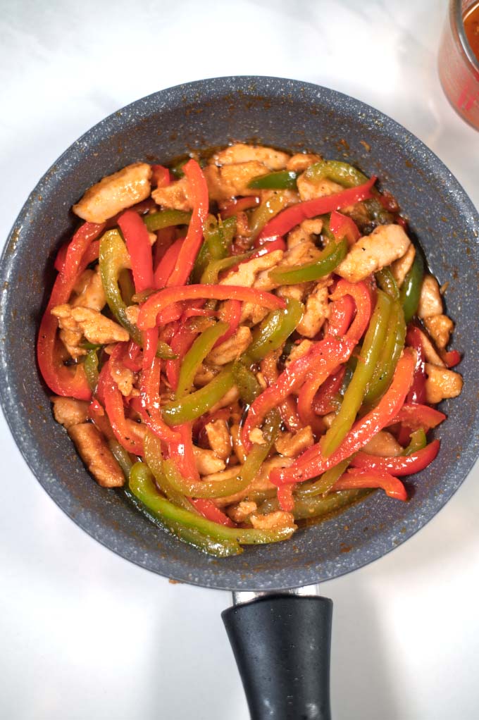 Fajita Sauce in a pan with chicken and red and green pepper.