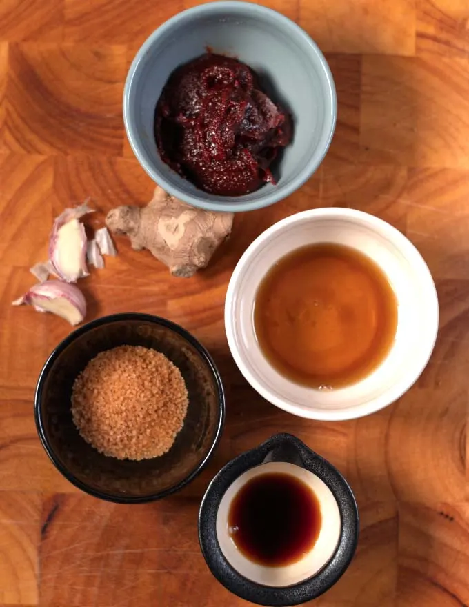 Ingredients needed to make Gochujang Sauce on a wooden board.