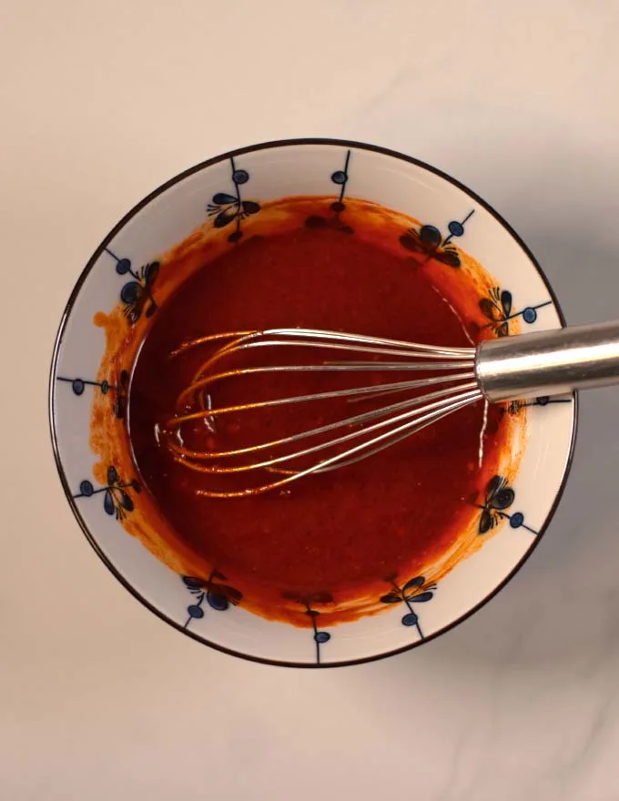 A mixing bowl with a wire whisk.