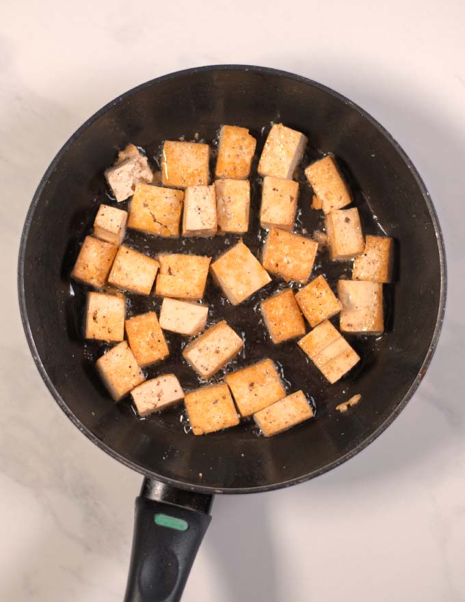 Step-by-step picture showing frying of tofu cubes.