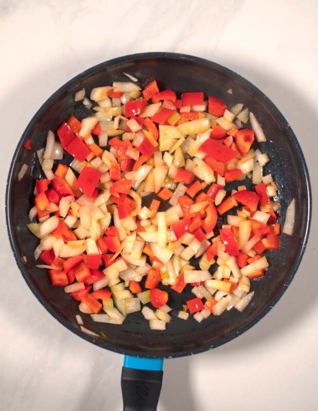 Vegetables are fried in a pan.