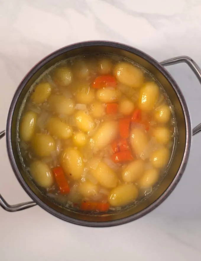 Potatoes and carrots are cooked in vegetable broth.