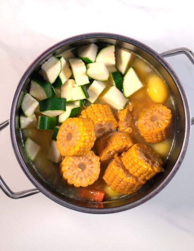 Zucchini and corn are given into the large pot.