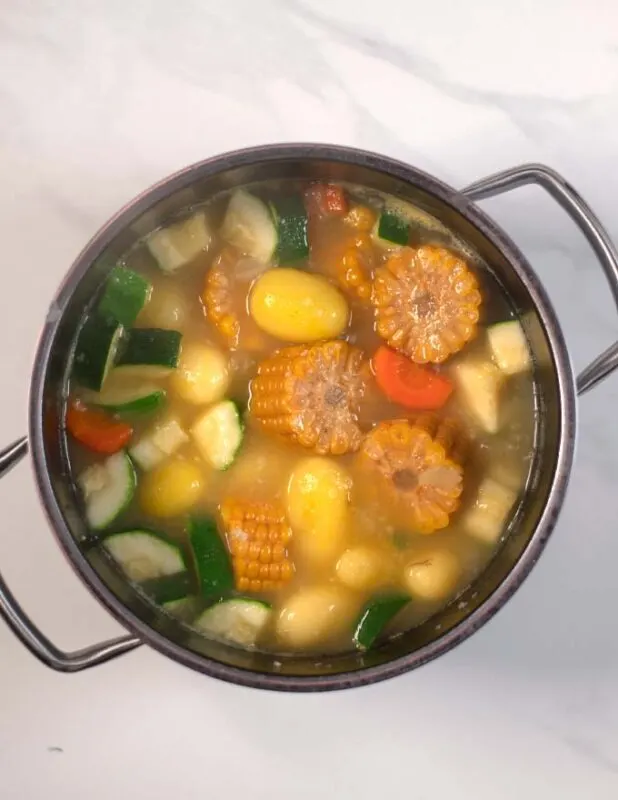 Vire of a large pot with vegetables in broth.