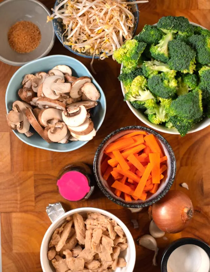 Ingredients needed to make Chinese Chop Suey collected on a wooden cutting board.