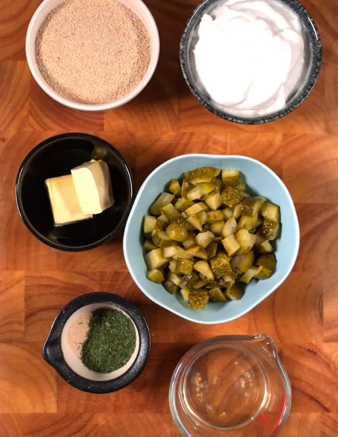 Ingredients needed to make Fried Pickle Dip are collected on a board.