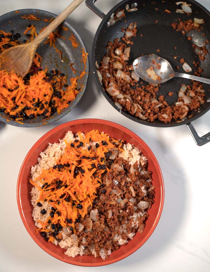 A plate with Kabuli Pulao and pans in the background.