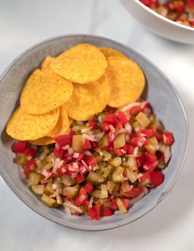 Top view of a serving of Pickle de Gallo with nacho chips.