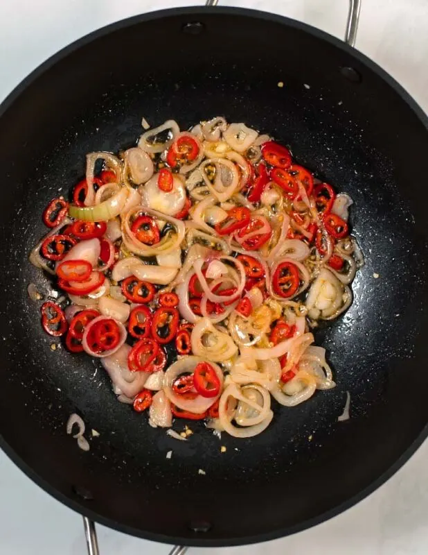 Vegetables for Thai Vermicelli are fried in a wok.