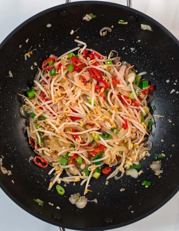 Bean sprouts and green onions are added to the wok.