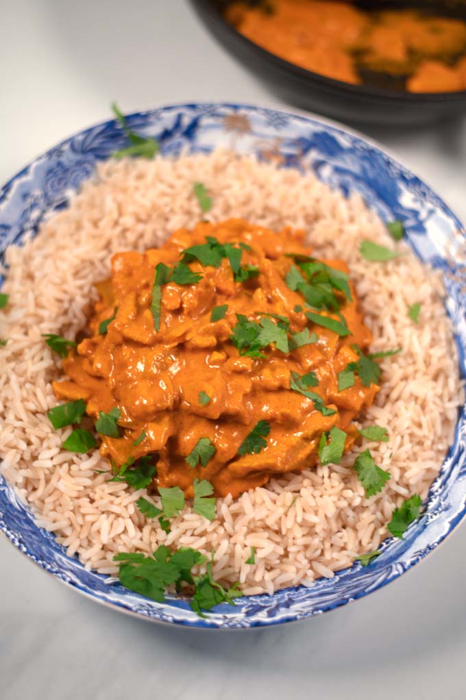 Closeup on a serving of Best Indian Curry with rice and garnished with fresh cilantro.