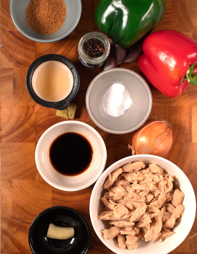 Ingredients needed to make Pepper Chicken collected on a board.