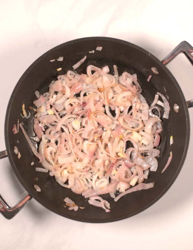 Shallots are sauteed in a pan.