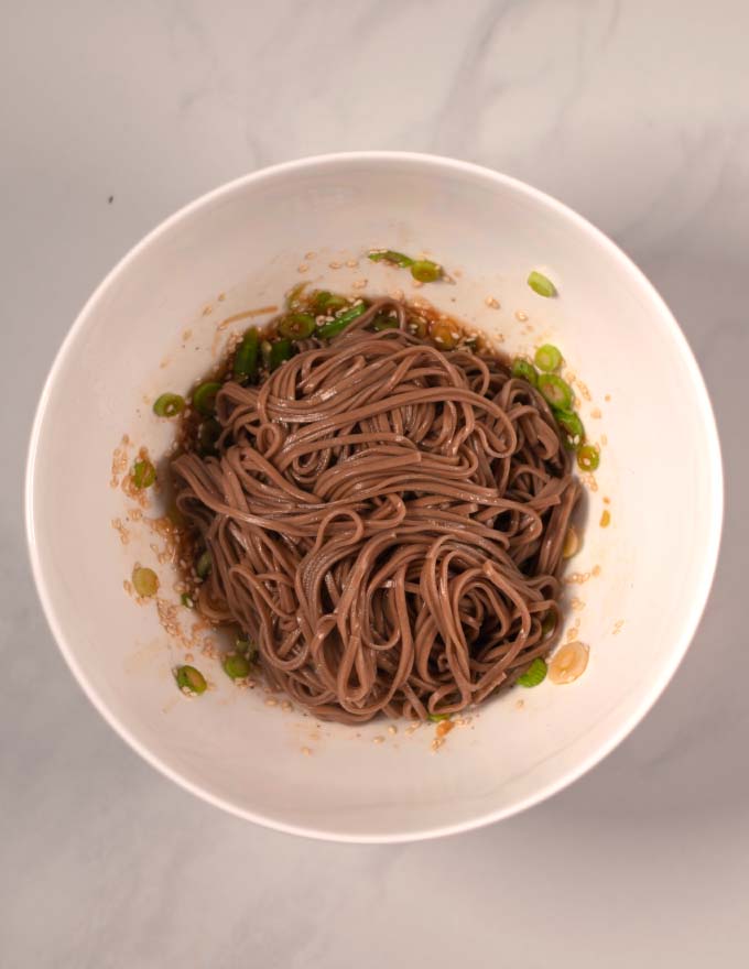 Soba noodles are give to the bowl.